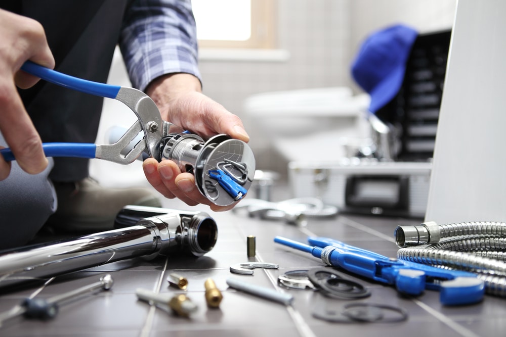 Image of a plumber repairing a faucet with eco-friendly plumbing tools.